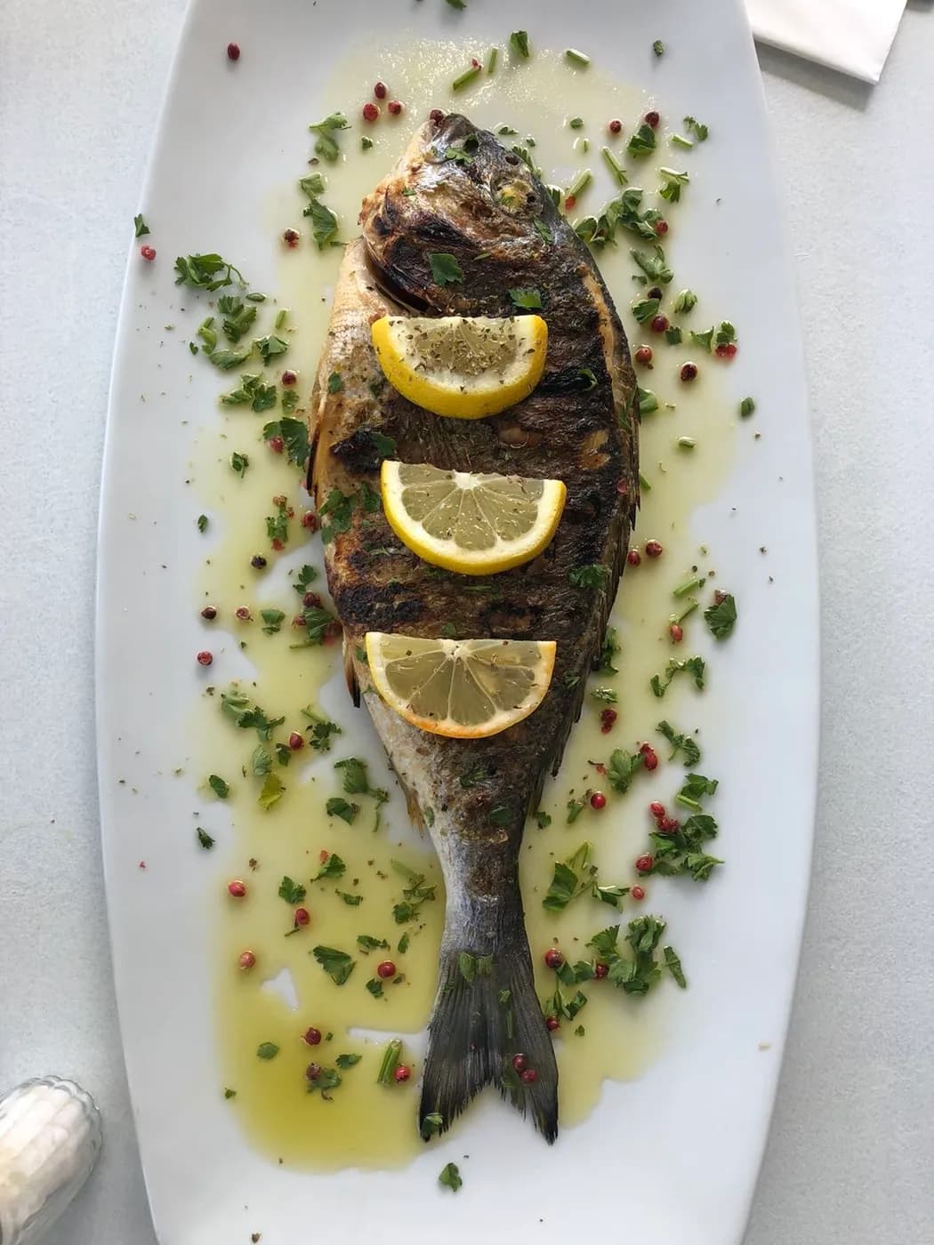 Charcoal-grilled sea bream, served with oil and lemon
